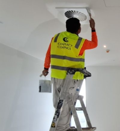 painter painting ceiling with paint brush